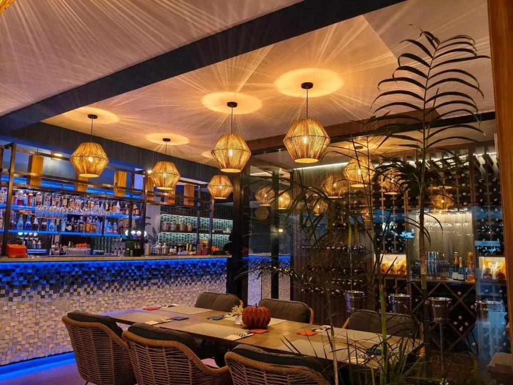 Restaurant dining area at Gooseberry Baan Bistro with a natural wood mosaic feature wall